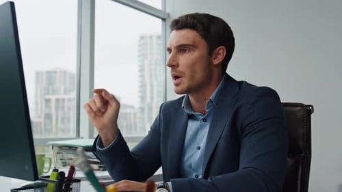 Man in Suit Video Conferencing at Office Desk