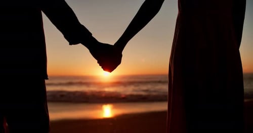 Silhouette, couple and holding hands on beach at sunset for romantic date, sightseeing and holiday