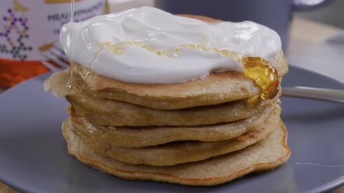 Honey Drizzled on Stack of Pancakes With Cream