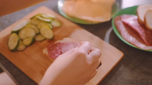 Preparing Sandwich with Salami Cheese and Pickles