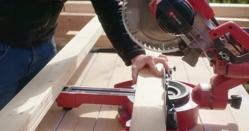 Man Cutting Wood with a Miter Saw
