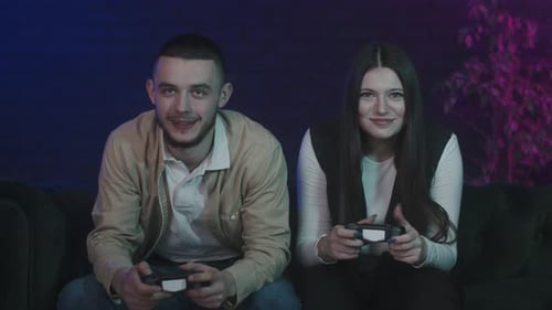 Couple Playing Video Games at Night on Sofa