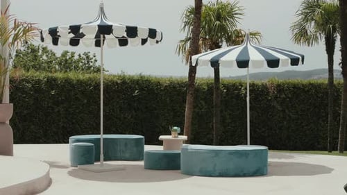 striped parasols and blue seating in stylish summer patio lounge