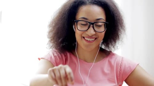 Smiling woman with headphones dancing indoors