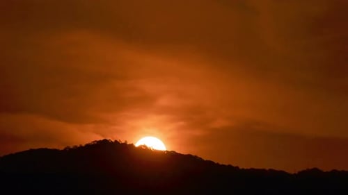 Golden Sun Rises Above Mountain in Time Lapse