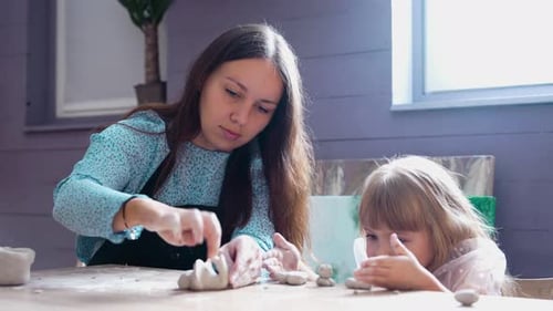 Adult and Child Sculpting with Clay at Table
