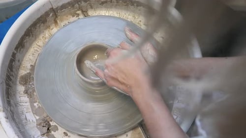 Hands Shaping Clay on Pottery Wheel in Studio