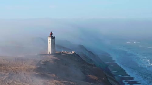 Lighthouse Rubjerg Knude Fyr in fog at the coast of Denmark in the morning