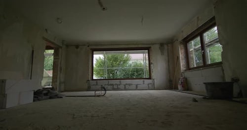 Wide shot on a construction site, living room gets renovated, camera tracks towards a huge window, b