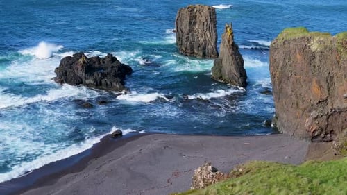 Aerial view of rugged cliffs and ocean waves, Iceland.