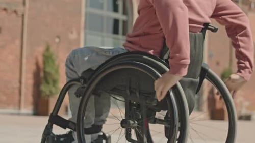 Unrecognizable Man Riding Wheelchair in Urban Environment