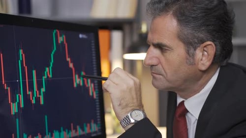 Stock trader mature man following the stock market thoughtfully.