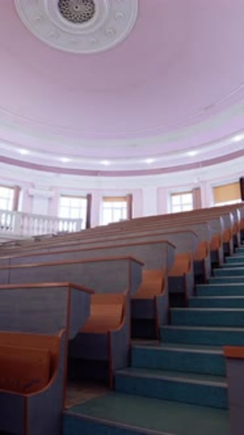 Un centro educativo sin nadie. Auditorio vacío con escritorios de madera
.