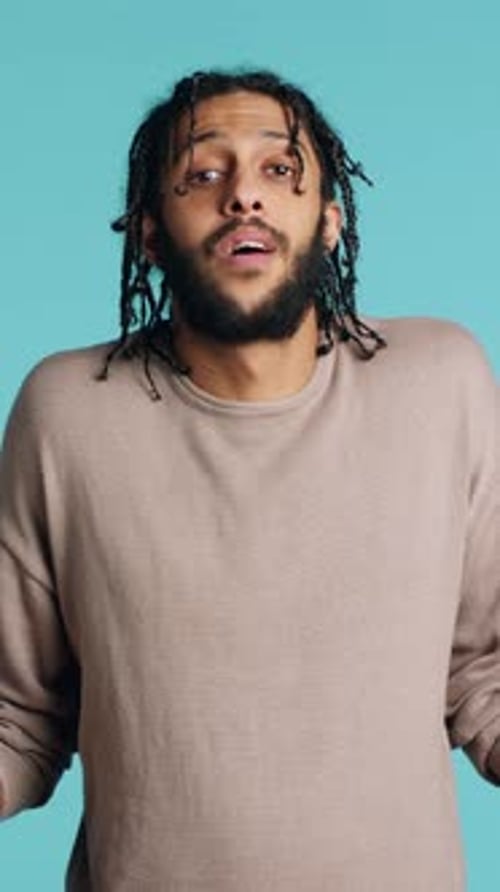 Vertical Video Uncaring Man Shrugging Shoulders Showing Indifference Studio Background