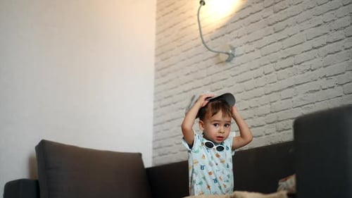 Cute Toddler Tries to Put on Baseball Cap