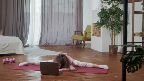 Girl Stretches Doing Splits with Laptop