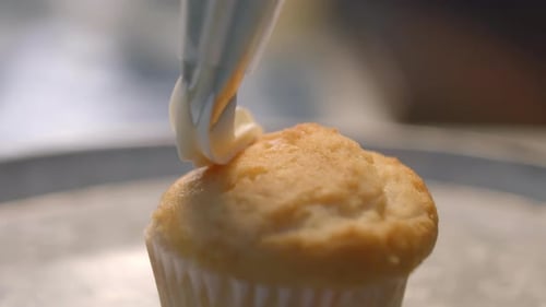Cupcake Receives Swirls of Sweet White Frosting