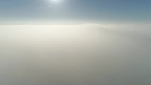 Flight over misty clouds in morning sunlight with little glory and city scape under clouds