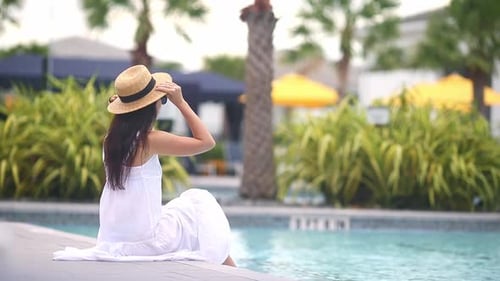Young Beautiful Woman Enjoying Summer Vacation in Infinity Luxury Swimming Pool