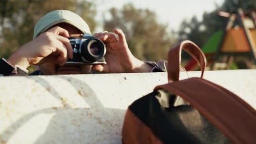Photographe se cachant derrière un banc et prenant une photo