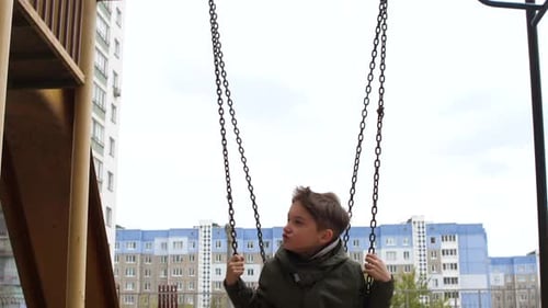 Boy Child Playing on Swing an Playground Child Swinging on Swing in City
