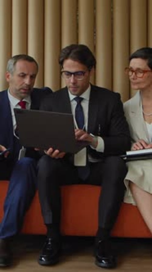 Business Colleagues Discussing a Presentation on a Laptop