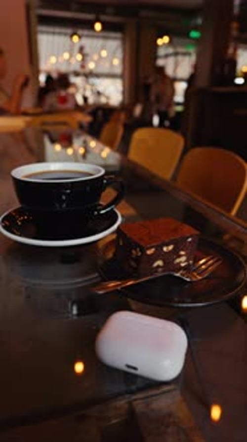 Coffee Cup, Brownie and Earbuds on Cafe Table