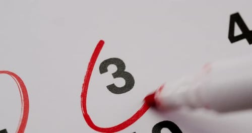 Marking Date on a Calendar with Red Marker