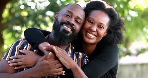 Smiling Couple Embracing in a Green Outdoor Setting
