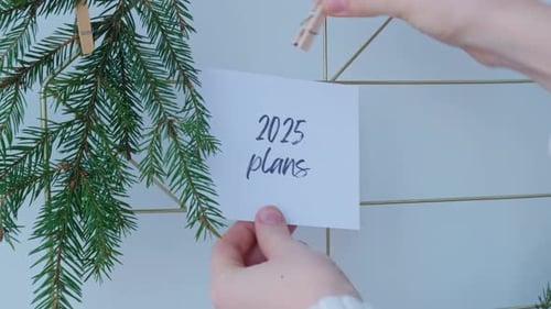 2025 PLANS Text on White Paper Note on Vision Board with Christmas Decor New Year Aims Resolutions