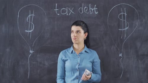 The woman who writes Tax Debt on the blackboard looks at her with a languid expression.