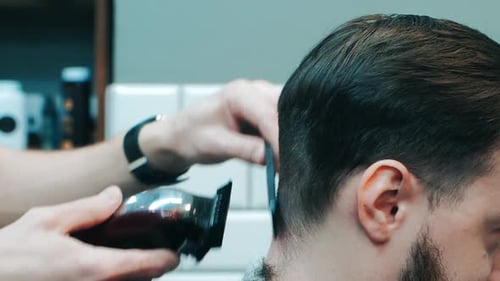 Friseur schneidet dem Kunden die Haare am Hinterkopf. Friseur schneidet Haare