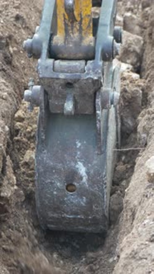 Excavator Bucket Digging a Trench