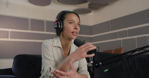 Young Adult Female Podcaster in Studio Recording Podcast, Wearing Headphones