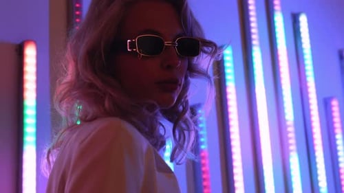 Stylish Woman with Sunglasses Posing in Neon Light