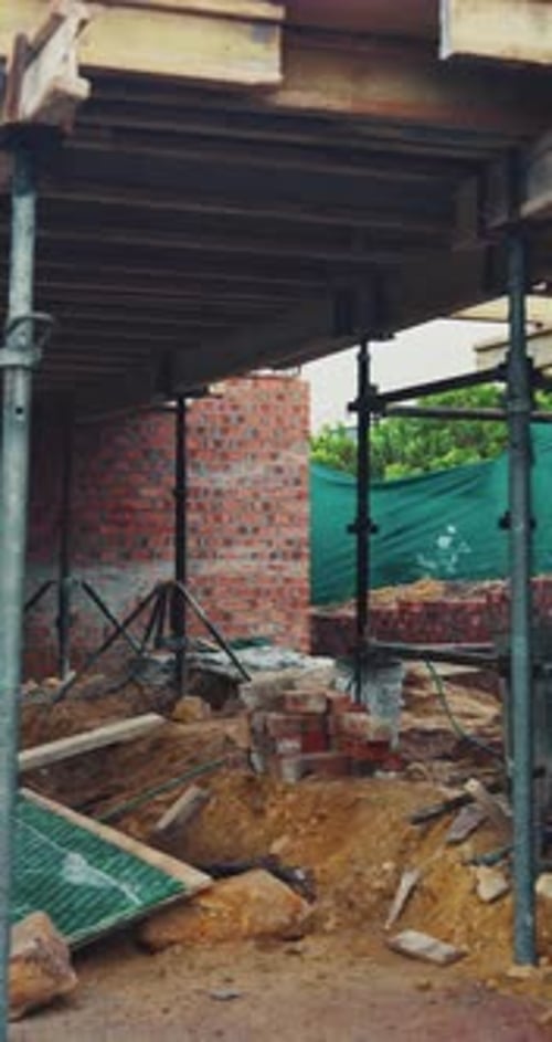 Exterior, andamios y sitio vacío para la construcción, los cimientos y la estructura del edificio