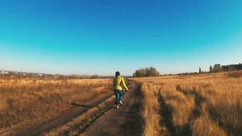 Person Running with Dog in a Golden Field