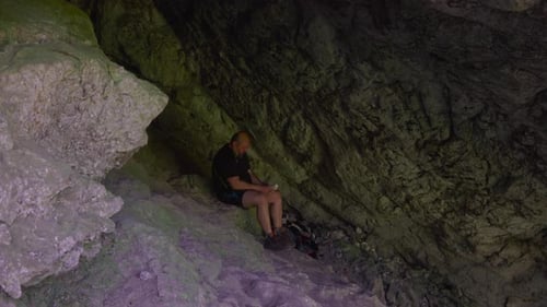 Hiker relax and read books outdoor, in a cool cave