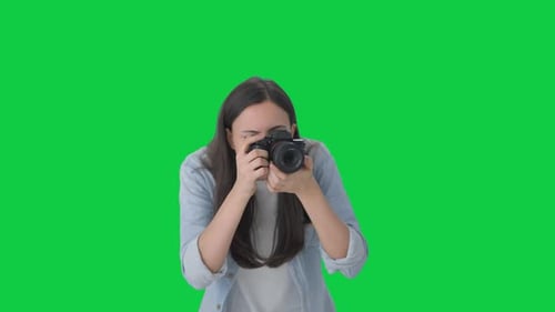 Indian girl clicking photos using a camera Green screen