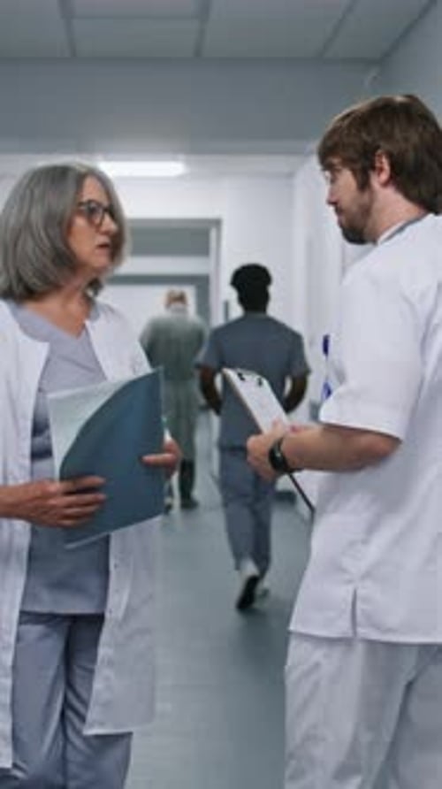 Doctors Discussing Patient Care in Hospital Corridor