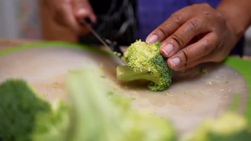 Cutting broccoli for a homemade stir fry meal - slow motion