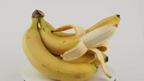 Ripe Yellow Bananas Rotating on White Surface