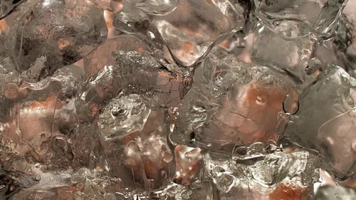 Yummy liquid runs into the cocktail glass in 1000 fps slow-motion. Glass full of ice cubes gradually