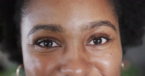 Close up portrait of eyes of happy african american woman smiling, in slow motion