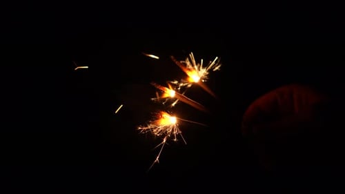 Sparkling holiday sparklers glowing in the dark night