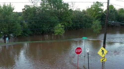 American town submerged in tropical storm hurricane flood waters. Streets, roads, signs under rain w