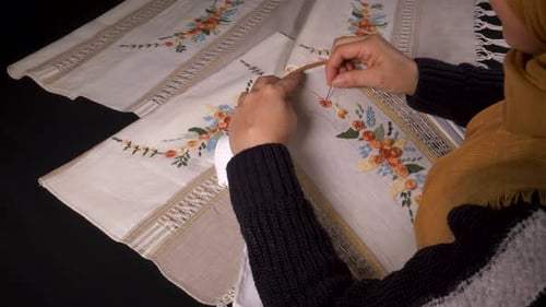 Woman Embroidering Floral Design on Linen Fabric