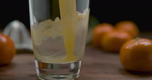 Tangerine Juice Being Poured into Glass