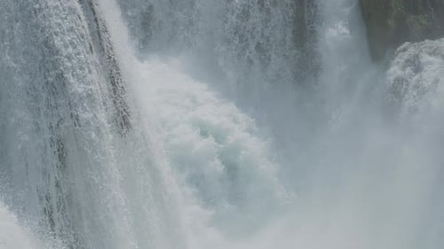 Une cascade avec une grande quantité d'eau sur une rivière de montagne propre et sauvage. Plan rapproché de l'eau