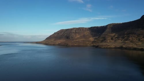 Aerial video over landscapes of mountains, lakes, and roads in Iceland